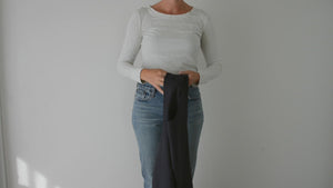 woman showing how to wear the cross-back linen pinafore apron from portland apron company.