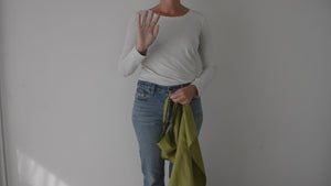 woman showing how to wear the organic split leg potters apron in chartreuse green linen by portland apron company. 